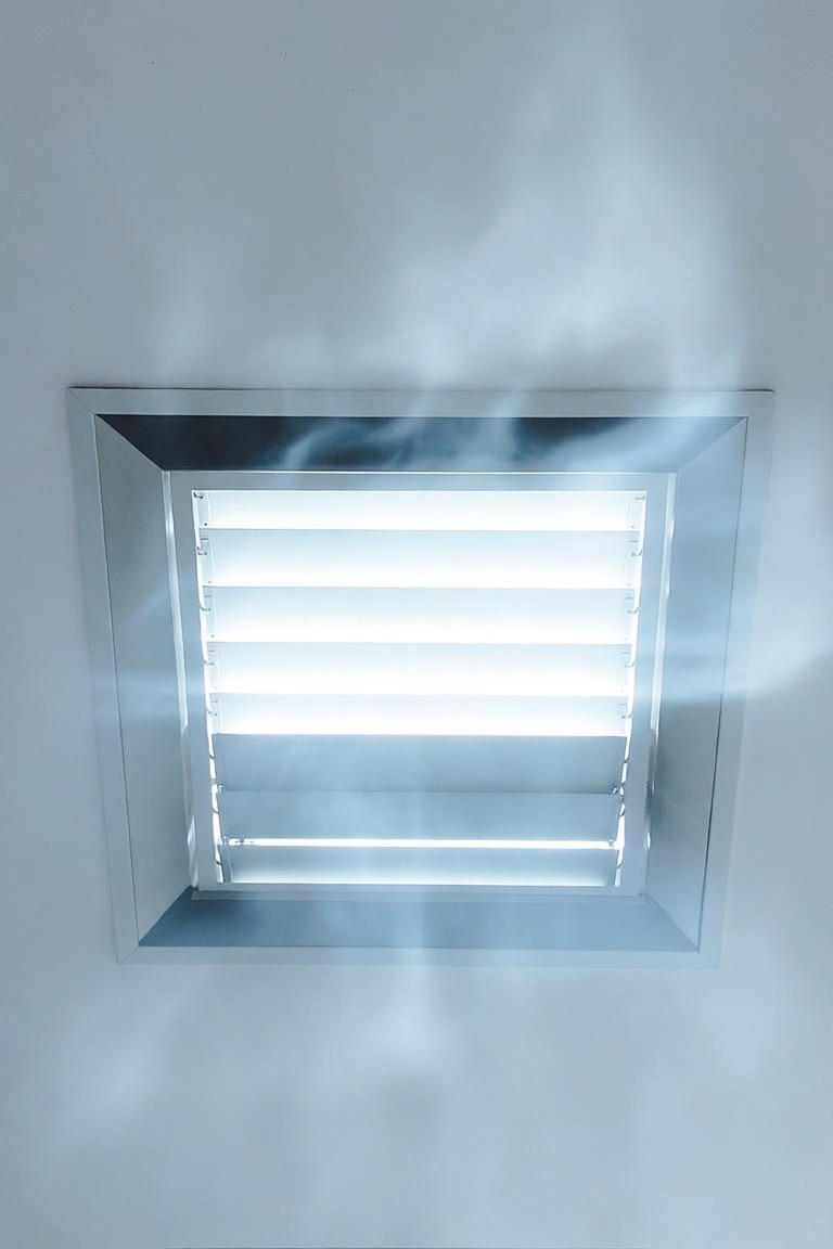 An open ceiling supply vent inside a residential home with visible airflow